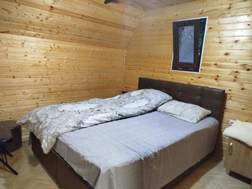a bedroom with a bed in a wooden cabin at Roinis Villa in T'khilnari