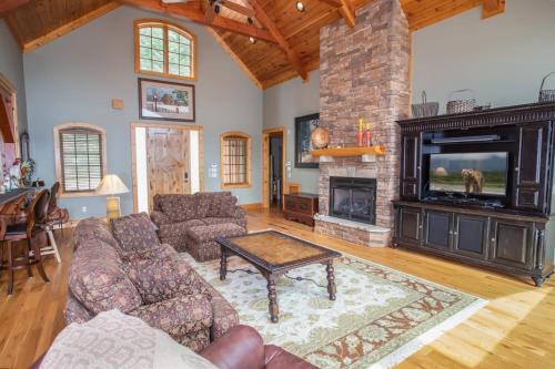 a living room with a fireplace and a tv at Ridgeline Cabin in Elk Park