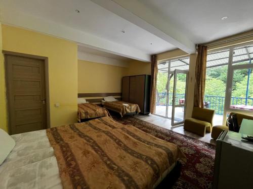 a hotel room with two beds and a window at Riviera Guesthouse in Dilijan