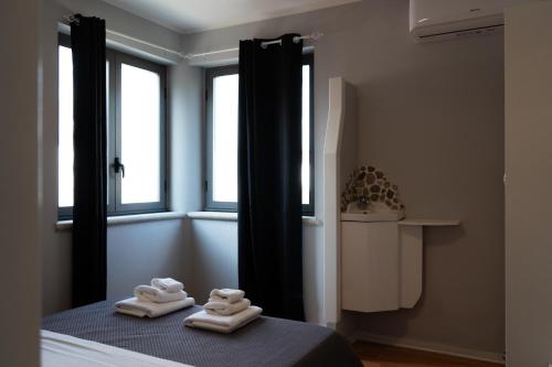 a bedroom with two towels on a bed with windows at Central Viale in Telese
