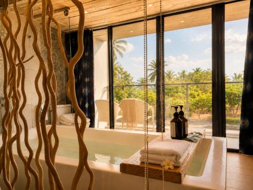 a room with a bath tub with a large window at 湛藍海岸民宿 Azure-墾丁南灣沙灘-可包棟-國旅卡 in Nanwan