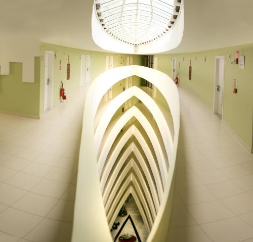 a hallway of a building with a curved wall at Hotel Dunamys Curitiba in Curitiba