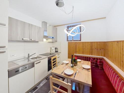 a kitchen with a wooden table and red chairs at Apartment Höllwarth by Interhome in Fügenberg