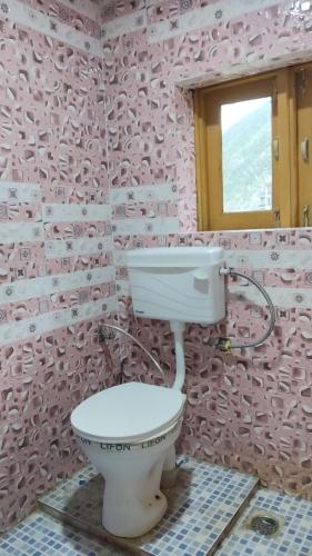 a pink bathroom with a toilet and a window at Samoon guest house in Wāmpor