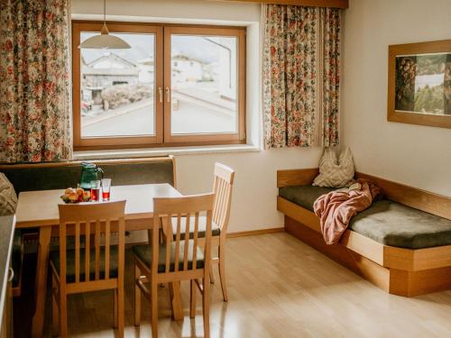 a dining room with a table and a bench with a window at Apartment Kraftreich Apartments-4 by Interhome in Aschau