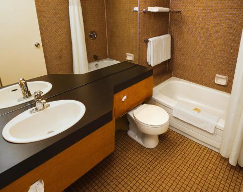 a bathroom with a sink and a toilet and a tub at Hôtels Gouverneur Rimouski in Rimouski
