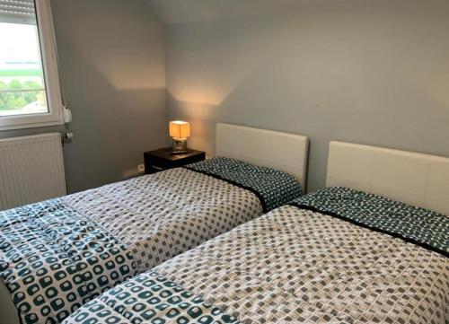 two beds sitting next to each other in a bedroom at La Cour des Miracles Gîte in Sequehart