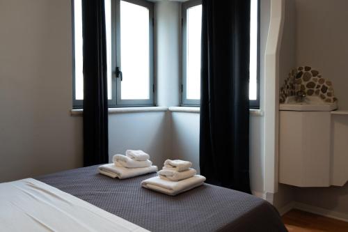 two towels on a bed in a room with windows at Central Viale in Telese