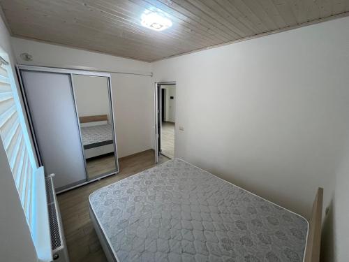 an empty room with a bed and a mirror at Nishkoiu Apartamente in Solotvyno