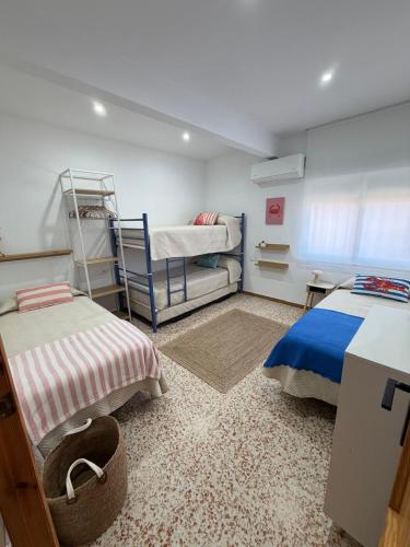 a bedroom with two beds and a bunk bed at Apartamento SOLYMAR Chipiona in Chipiona