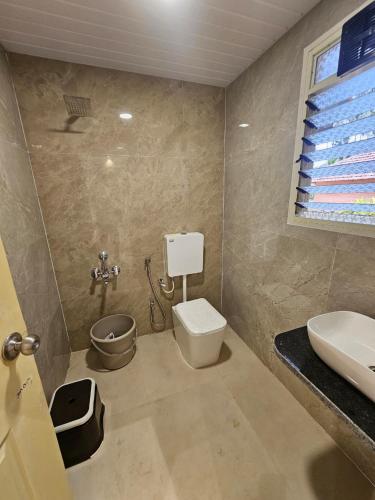 a bathroom with a toilet and a sink at Saavi Resort Shrivardhan in Srīvardhan
