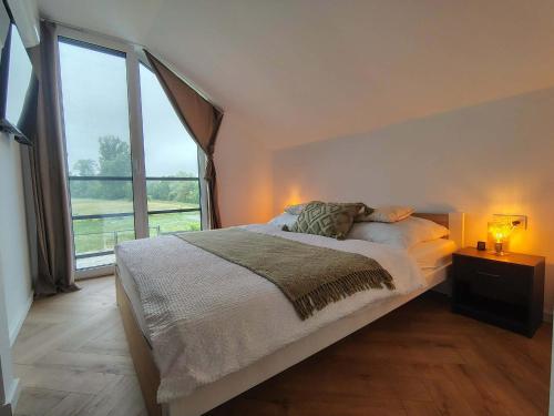 a bedroom with a bed and a large window at Dovolenkový domček in Sabinov