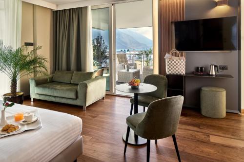 a hotel room with a bed and a living room at Hotel Kristal Palace - Tonelli Hotels - Adult Friendly in Riva del Garda