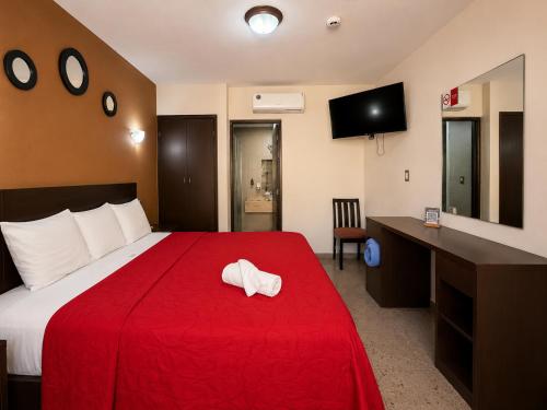 ein Hotelzimmer mit einem Bett mit einer roten Decke in der Unterkunft Hotel ROLOVI in Veracruz