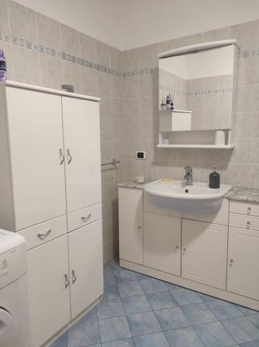 a white bathroom with a sink and a mirror at CASA BETTO in San Domenico