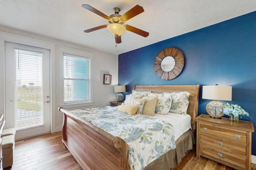 a bedroom with a bed and a ceiling fan at Point West Resort in Galveston