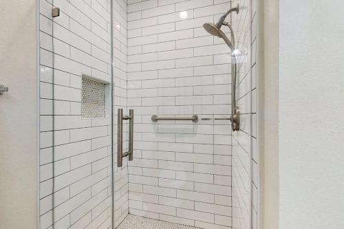 a bathroom with a shower with white tiles at Point West Resort in Galveston