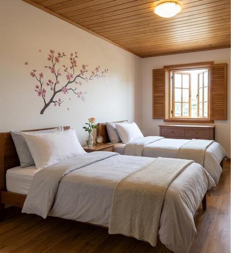 a bedroom with two beds and a tree on the wall at Apartamentos El Cuetu in Llanes