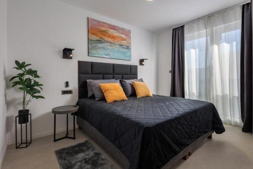 a bedroom with a large bed with orange pillows at Villa Sunset with swimming pool in Baška