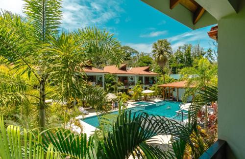 an aerial view of a resort with a pool and palm trees at Bungalows Beachfront Hotel in Punta Uva