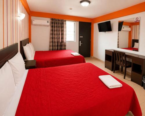 ein Hotelzimmer mit zwei Betten und einem Schreibtisch in der Unterkunft Hotel ROLOVI in Veracruz