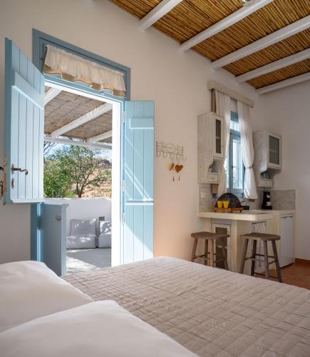 a bedroom with a large bed and a kitchen at Toffee in Kimolos