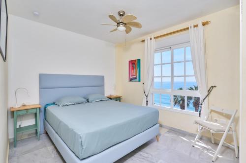 a bedroom with a bed and a window and a chair at Blue View in Torrox Costa