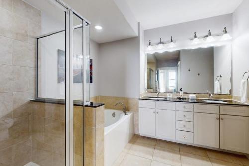 a bathroom with a shower and a sink and a tub at Sand Swept in Galveston