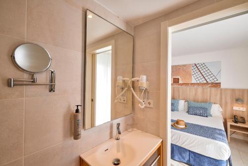 a bathroom with a mirror and a sink and a bed at INNER Hotel Rupit "Adults Only" in Cala d´Or