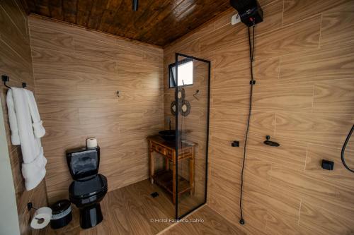 a bathroom with a shower in a wooden wall at Hotel Fazenda Gabro - Vitra in Apiaí