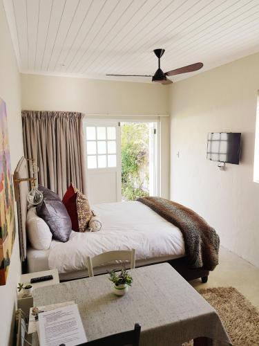 a bedroom with a bed with pillows and a window at Knysna Holiday Cottage in Knysna