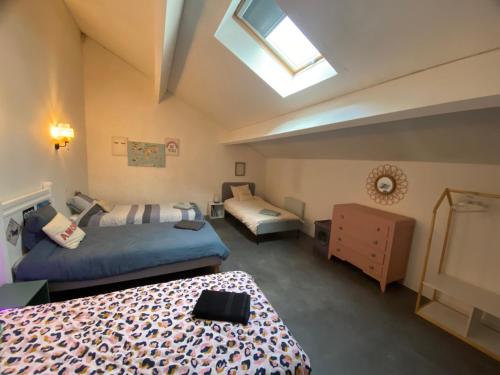 a bedroom with two beds and a skylight at Villa émeraude in Cublac