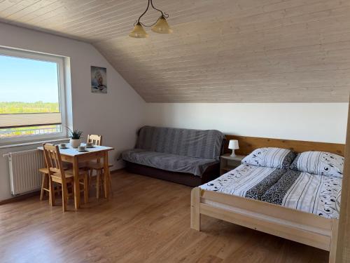 a bedroom with a bed and a table and a couch at Flota in Ostrowo