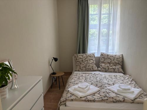 a small bedroom with a bed and a window at Rosenwohnung in Neustrelitz