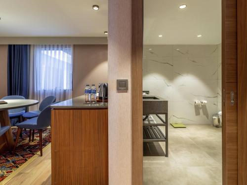 pokój hotelowy z barem, stołem i krzesłami w obiekcie Mercure Trabzon Hotel w mieście Trabzon