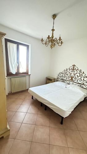 a bedroom with a white bed and a window at Casa Tassistro in Pareto