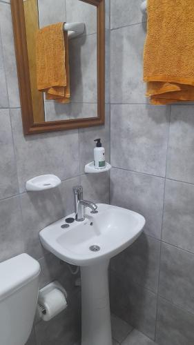 a bathroom with a sink and a toilet and a mirror at Brisa de Pueblo in Caseros