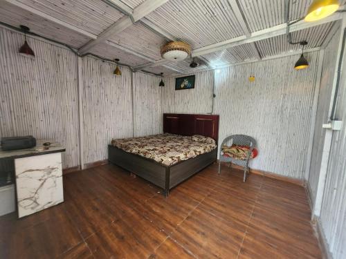 a bedroom with a bed and a chair in it at Aradiya Farm House in Noida