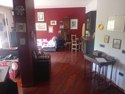 a living room with red walls and wooden floors at Modena Sound Suite in Modena