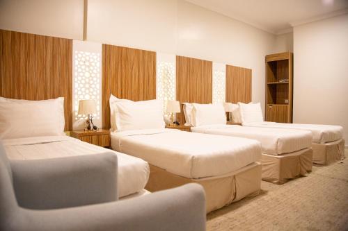 a hotel room with three beds in a room at Artal Taiba Hotel in Medina