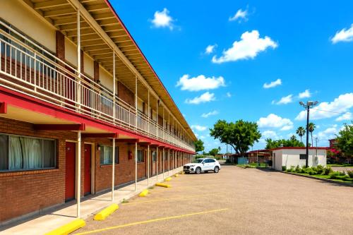 a white car parked in front of a building at Pen Ann by Capital O Pharr-McAllen TX in Pharr