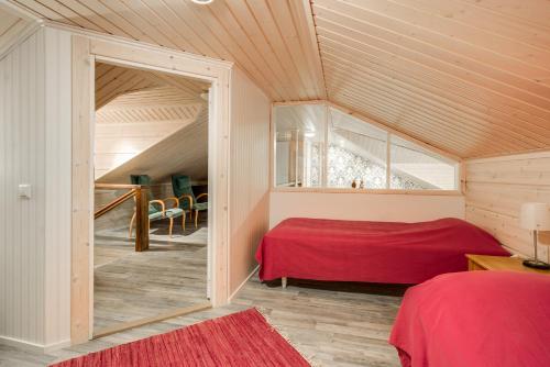 a bedroom with a red bed in a attic at Holiday Home Kerssintie in Tahkovuori