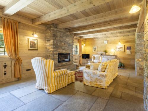 a living room with two chairs and a fireplace at Chalet Chalet Anna by Interhome in Grosotto
