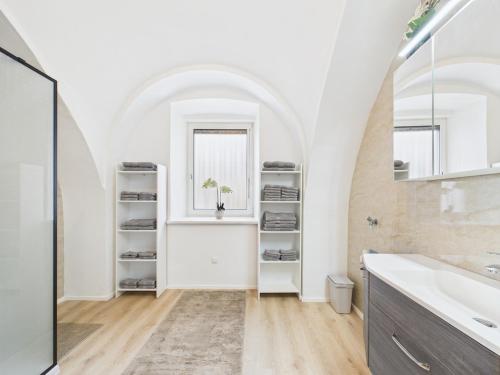 a white bathroom with a sink and a mirror at Ebenerdige Ferienwohnung in Maissau