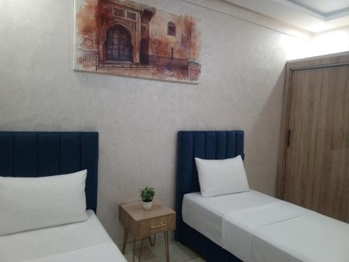 a room with two beds and a table at Riad Bollywood Spacious 5 Beds Stay in Benguerir