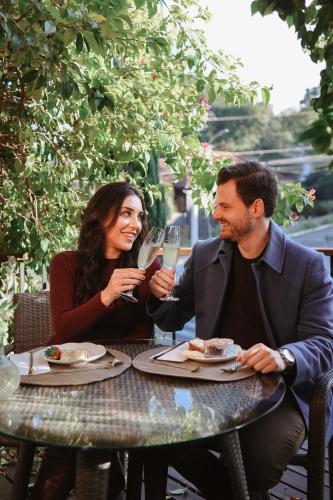 a man and woman sitting at a table drinking champagne at Blumen Hotel Boutique in Canela