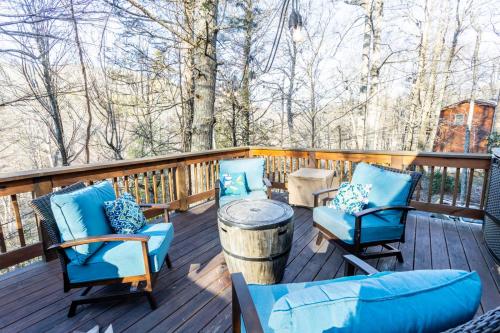 a deck with blue chairs and a table at Stoney Brook Cabin in Boone