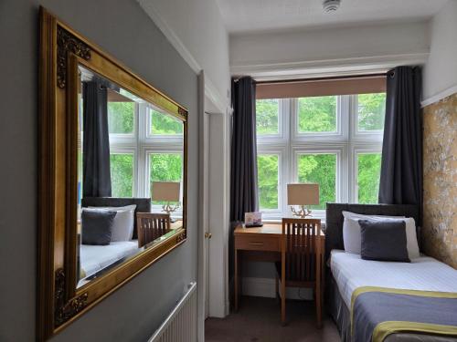 a bedroom with a mirror and a desk with a desk at Sawrey House in Near Sawrey