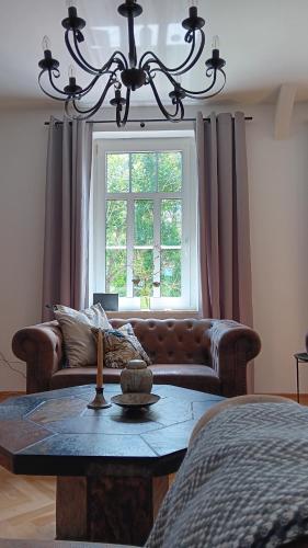 a living room with a couch and a table and a window at Holiday Apartment Henry - Auszeit unter alten Balken in Arnstadt