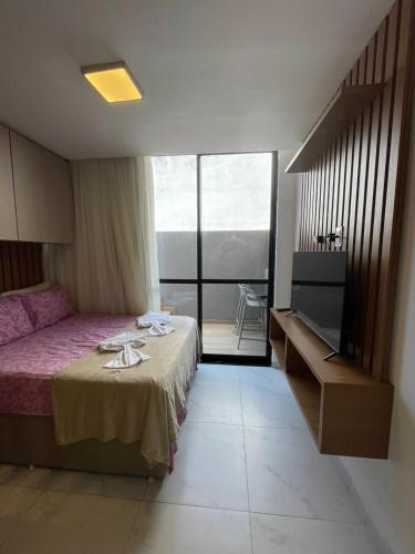 a hotel room with a bed and a balcony at Porto City - Flat 06 com Jacuzzi in Porto De Galinhas